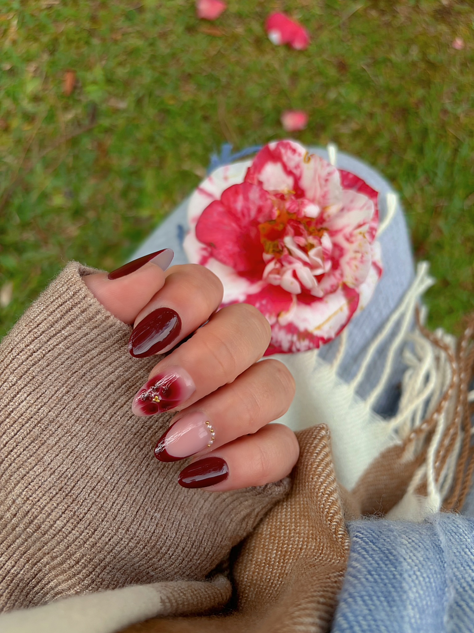 Unhas em vermelho escuro com detalhe floral e francesinha delicada